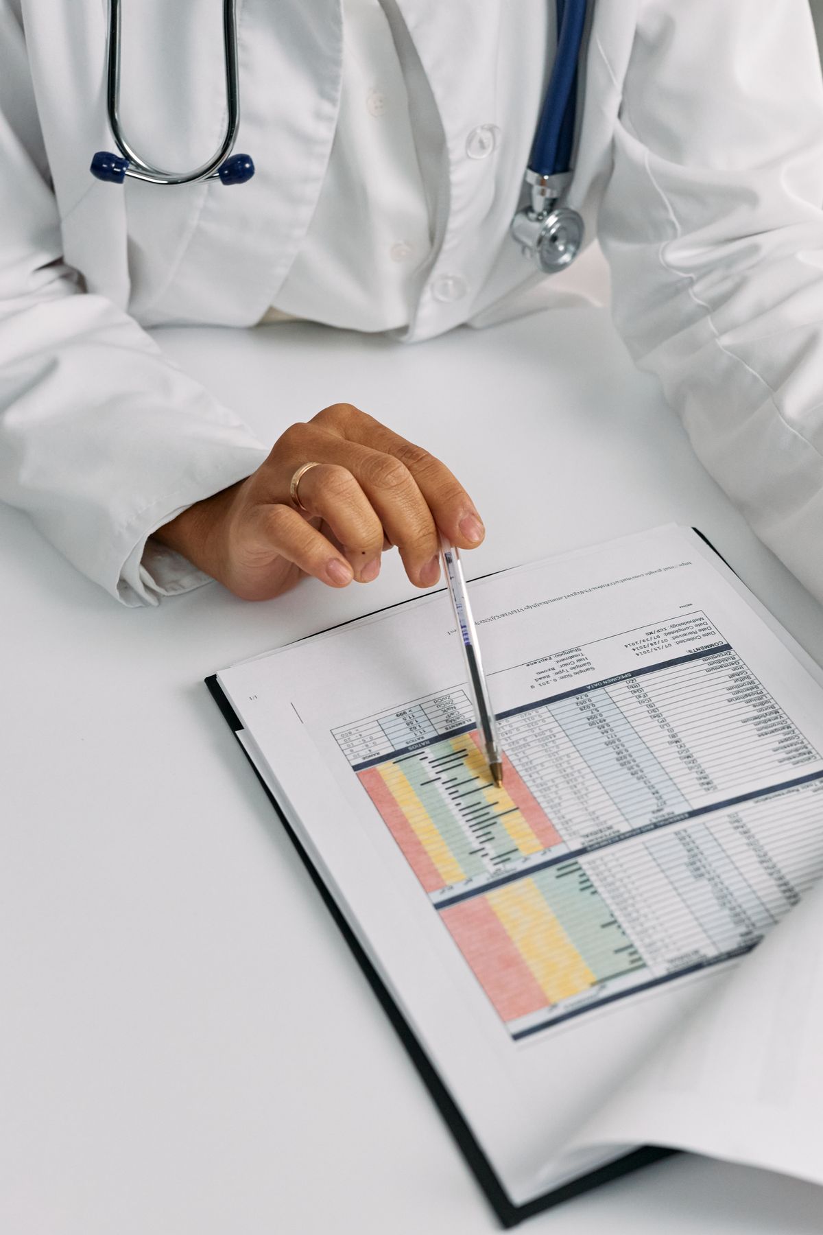 A physician reviewing a patient chart closely, marking key data points for a case review