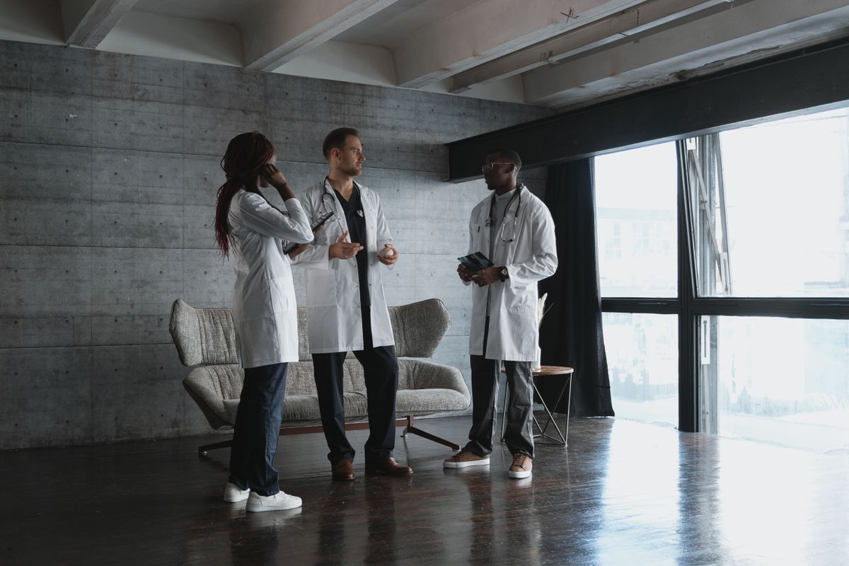 Three healthcare professionals discussing medical matters together in a modern office